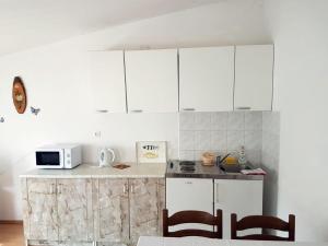 a kitchen with white cabinets and a counter top at Apartments S&M in Marina