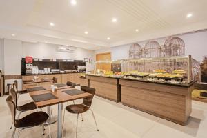 a restaurant with a table and chairs and a bakery at Slim Hotel Curitiba Av das Torres in Curitiba