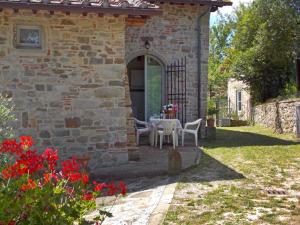 a stone house with a table and chairs in a yard at Holiday Home Casale Labbia by Interhome in Barberino di Mugello