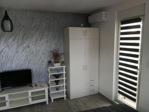 a living room with a white cabinet and a television at DANICA in Sremska Mitrovica