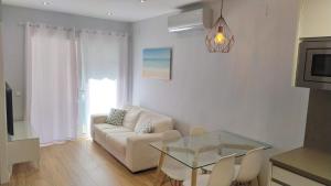 a living room with a couch and a glass table at Apartamento Blanes in Blanes