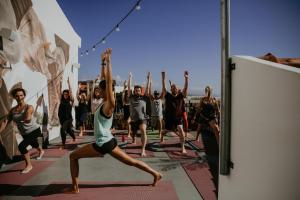 een groep mensen in een yogales bij Selina Ericeira by IKIGAI Global Hospitality in Ericeira