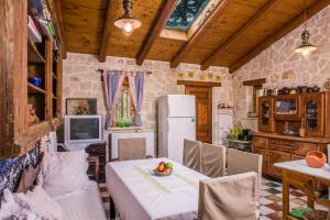 a kitchen with a table and a refrigerator at Jianni's Villa - Stone Villa in the Greenery!! in Vasilikos