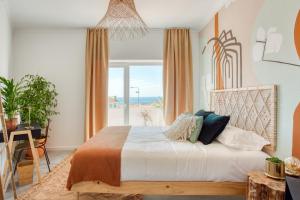 a bedroom with a bed with a view of the ocean at Selina Boavista Ericeira in Ericeira