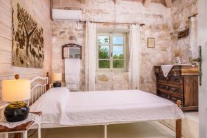a bedroom with a bed and a window at Jianni's Villa - Stone Villa in the Greenery!! in Vasilikos