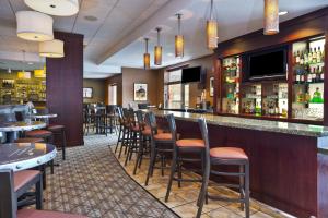 a bar in a restaurant with a bunch of stools at Holiday Inn & Suites Green Bay Stadium, an IHG Hotel in Green Bay