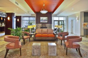 een lobby met een bank, stoelen en een tafel bij Holiday Inn & Suites Green Bay Stadium, an IHG Hotel in Green Bay