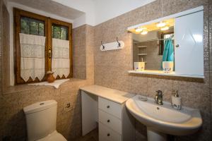 a bathroom with a sink and a toilet and a mirror at Jianni's Villa - Stone Villa in the Greenery!! in Vasilikos +18 photos