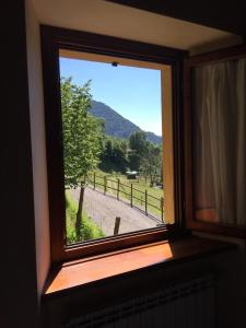 カスティリオーネ・ディンテルヴィにあるAgriturismo Il Talento Nella Quieteの野原の景色を望む部屋の窓