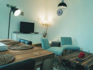 a living room with chairs and a table and a tv at La Belle Landaise 1809 Gîte Arridoulet 1 in Peyrehorade