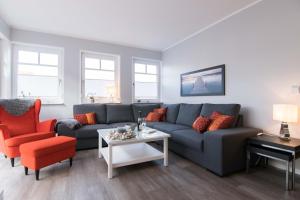 uma sala de estar com um sofá azul e uma cadeira vermelha em Ferienwohnung Stoneyard´s em Wustrow