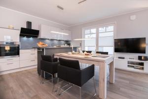 a kitchen with a table and chairs in a kitchen at Ferienwohnung Stoneyard´s in Wustrow