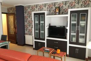 Una sala de estar con un sofá y un televisor de pantalla plana. en Sare Enea, en Bermeo