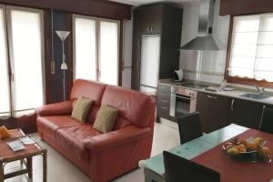 sala de estar con sofá rojo en la cocina en Sare Enea, en Bermeo