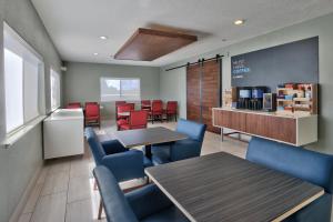 a restaurant with tables and chairs and a counter at Holiday Inn Express Hotel & Suites Albuquerque - North Balloon Fiesta Park, an IHG Hotel in Albuquerque