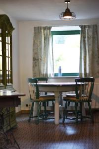 mesa de comedor con 2 sillas y ventana en Vakantiewoning Veurservallei, en Voeren