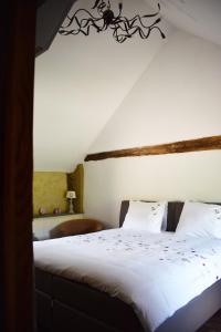 Schlafzimmer mit einem Bett mit weißer Bettwäsche in der Unterkunft Vakantiewoning Veurservallei in Voeren