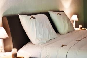 een bed met witte kussens met vogels erop bij Vakantiewoning Veurservallei in Voeren