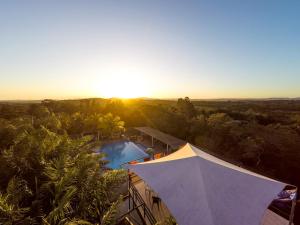 an overhead view of a resort with a pool and the sunset at Rumors Resort Hotel in San Ignacio