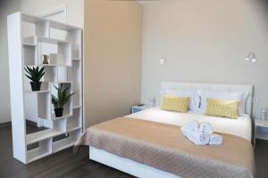 una camera da letto con un letto bianco con asciugamani sopra di Просторная однокомнатная ЖК Счастливый a Dnipro