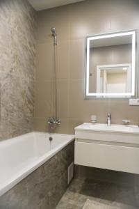 un bagno con vasca, lavandino e specchio di Просторная однокомнатная ЖК Счастливый a Dnipro Altre 42 foto