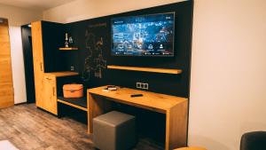 a room with a desk and a tv on a wall at Stadthotel Haslach in Haslach im Kinzigtal