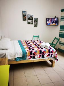 a bed with a colorful comforter in a room at Terraza Sancris in Tuxtla Gutiérrez