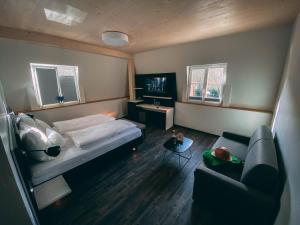 ein kleines Zimmer mit einem Bett und einem Sofa in der Unterkunft Stadthotel Haslach in Haslach im Kinzigtal