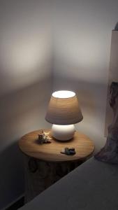 a lamp sitting on a wooden table next to a bed at Casa Noemi in Sperlonga