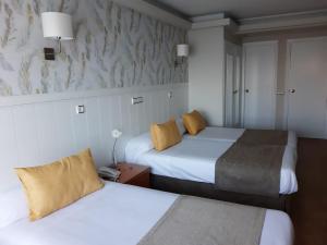 a hotel room with two beds and two lamps at Hotel Almirante in A Coruña