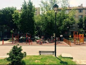 einen Park mit einer Bank und einem Spielplatz in der Unterkunft Brown Cottage Apartment in Sofia