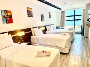 um quarto de hotel com duas camas e uma grande janela em Hotel Sun em Encarnación