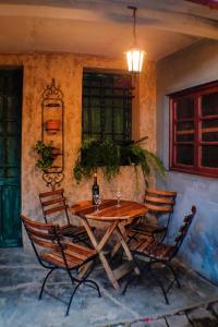 a wooden table with chairs and a bottle of wine at Hostel Running Chaski in Cochabamba