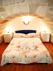 - une chambre avec un lit fleuri dans l'établissement Dimora la Sirenetta, à Polignano a Mare