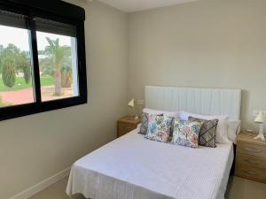 a bedroom with a white bed with pillows and a window at Baja B Beauty, Lo Pagan in Murcia +21 photos