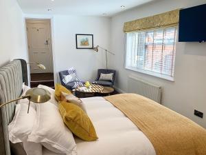 a bedroom with a bed and a chair and a window at Upstairs at 33 - Self check in boutique accommodation in Worcester Centre in Worcester