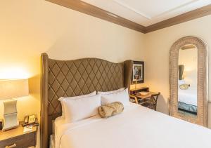 a hotel room with a large bed and a large mirror at Andrew Pinckney Inn in Charleston