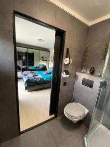 a bathroom with a toilet and a bedroom with a bed at Beach bungalow Hellevoetsluis in Hellevoetsluis