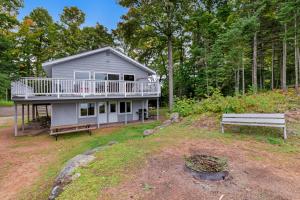 a house with a large deck and a bench at High Lake Hideaway in Boulder Junction