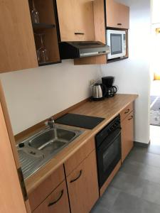 a kitchen with a sink and a microwave at Ferienwohnung Magdalena in Bodenmais