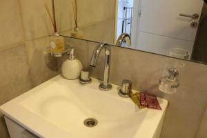a bathroom sink with a faucet and a mirror at Departamento nuevo y luminoso en el centro. in La Rioja +10 photos