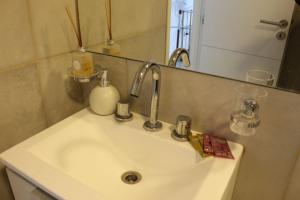 a bathroom sink with a faucet and a mirror at Departamento nuevo y luminoso en el centro. in La Rioja