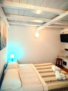 Cette chambre comprend un lit et une télévision. dans l'établissement Dimora la Sirenetta, à Polignano a Mare