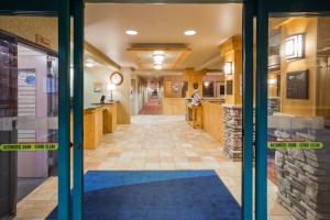 einen Flur eines Gebäudes mit einer Tür mit blauem Teppich in der Unterkunft Holiday Inn Express Hotel & Suites Brainerd-Baxter, an IHG Hotel in Baxter