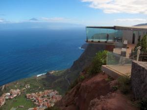 a building on top of a cliff next to the ocean at Casa Rural Sofia in Hermigua