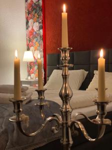 a bedroom with a bed with candles on a table at Der Tanzhase in Hasenmoor