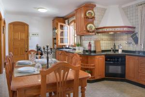 een keuken met houten kasten en een houten tafel bij ALIZUTH VILLA in Puerto del Carmen