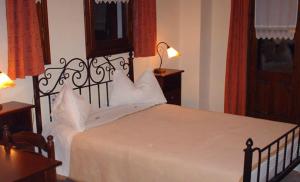 1 dormitorio con 1 cama grande con sábanas blancas en Guesthouse Mirihos, en Vlásti