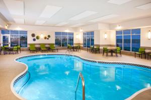 a pool in a hotel with tables and chairs at Holiday Inn Express & Suites Litchfield, an IHG Hotel in Litchfield