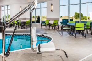 a swimming pool with chairs and tables in it at Holiday Inn Express & Suites Litchfield, an IHG Hotel in Litchfield